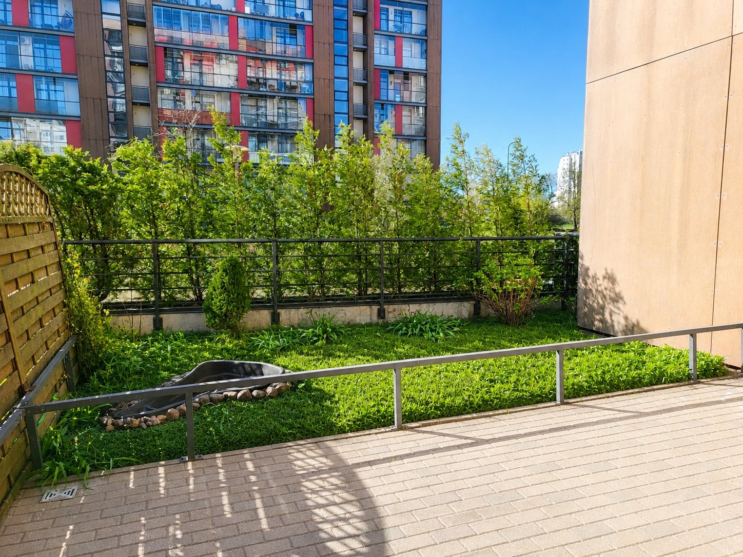 Green area beside the terrace with a hedge